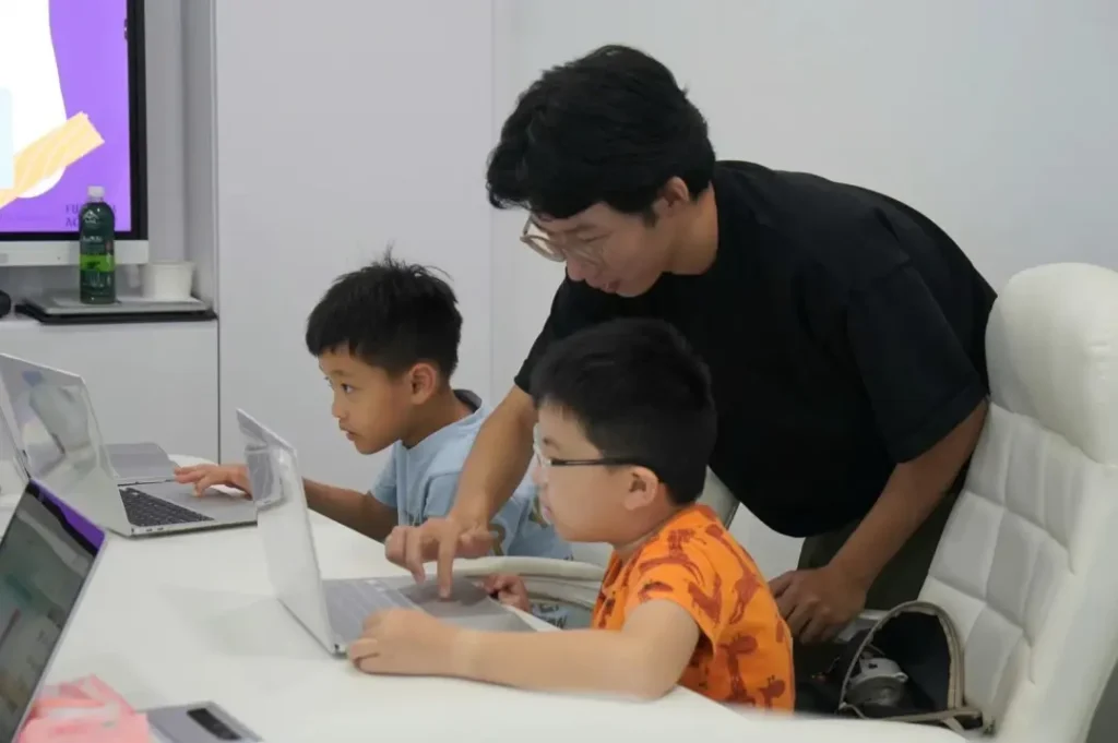 A Futurum Academy coach working through a build with two students