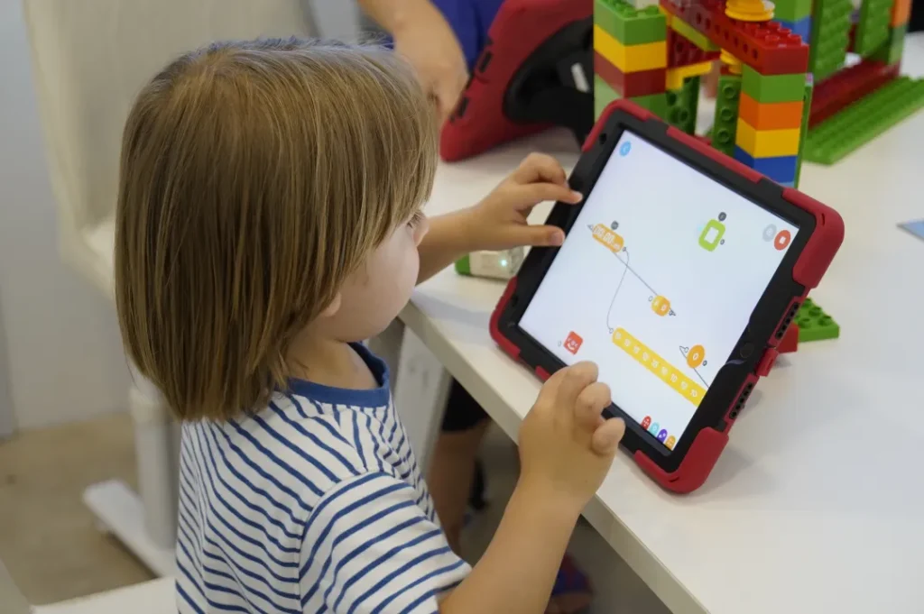 Young learners programming a block build on tablets in a Futurum Academy classroom